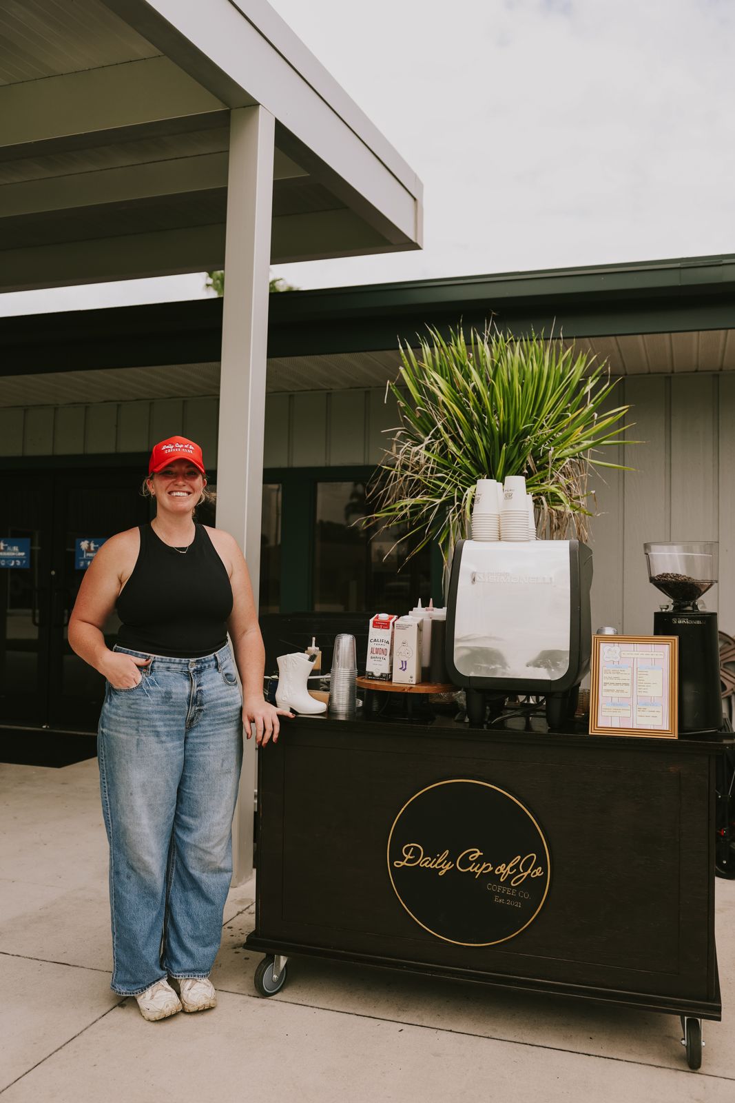 Standing at the Daily Cup of Jo cart in a red cap