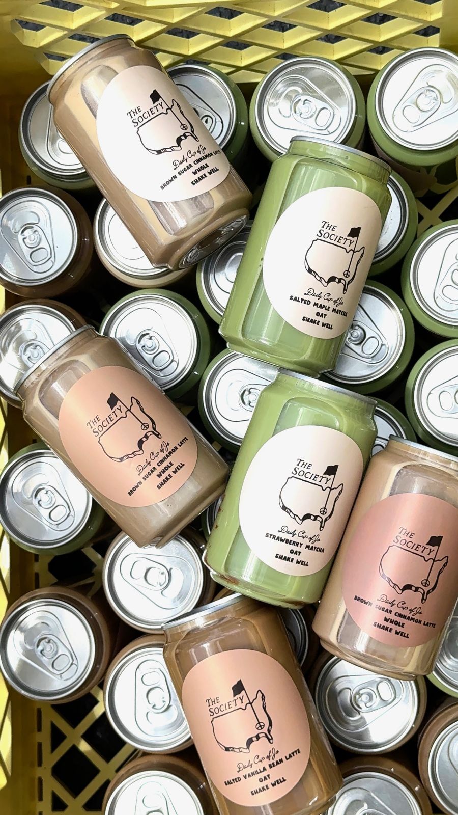 Canned Daily Cup of Jo lattes and matcha packed in a yellow crate