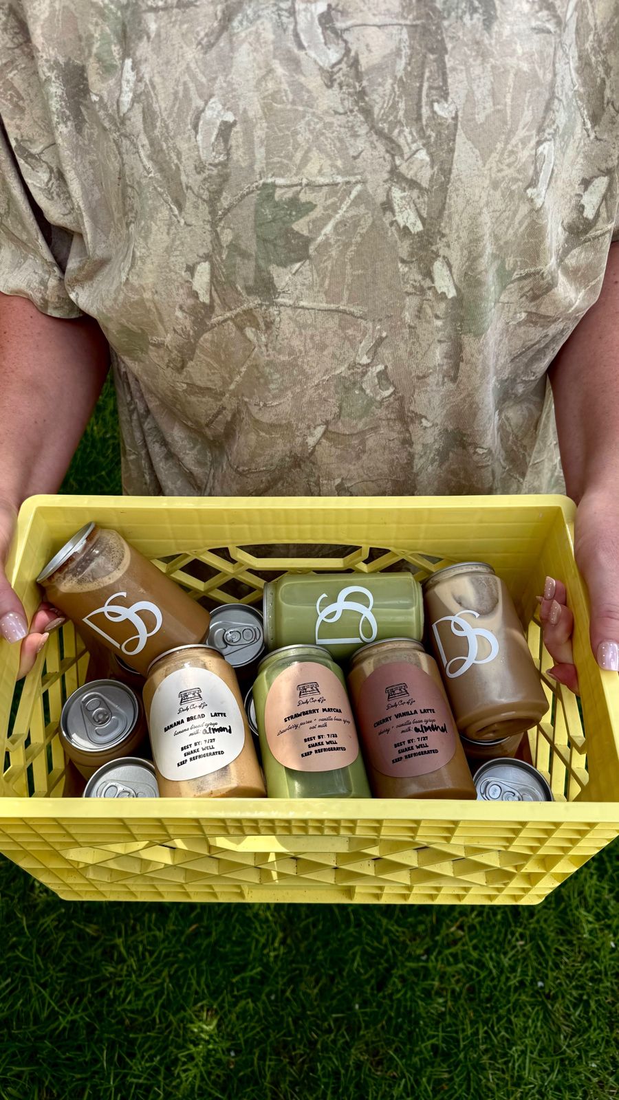 Holding a crate of canned lattes on the grass