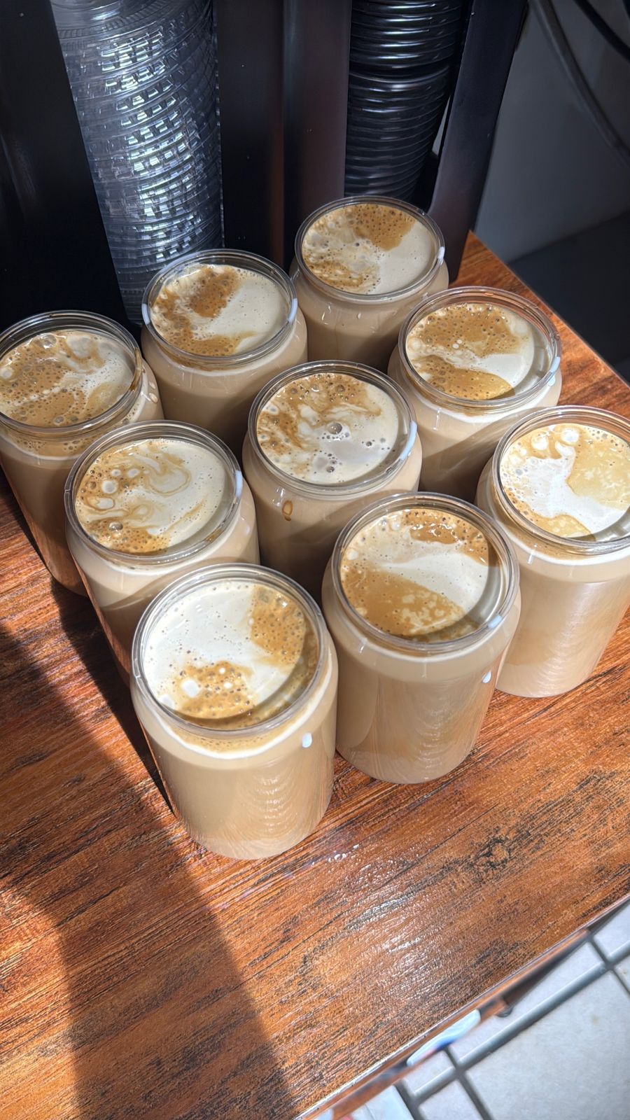 Jars of cold foam-topped lattes ready to be sealed