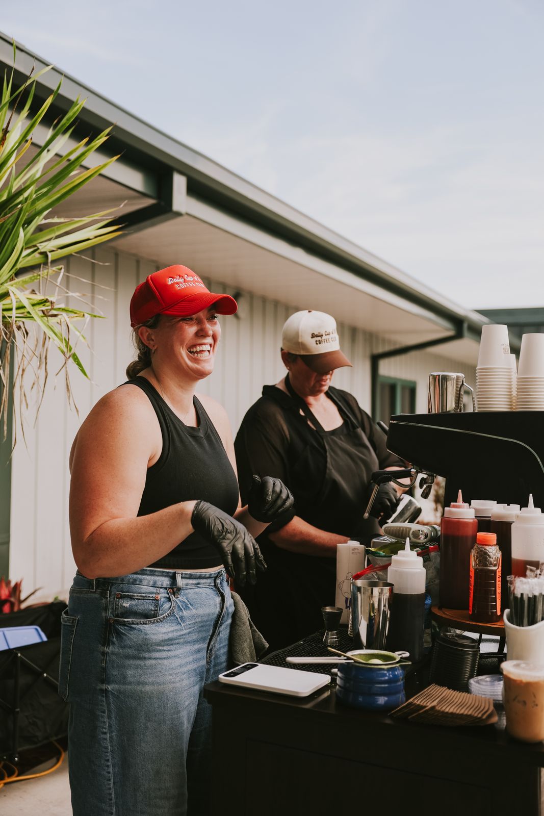 Two baristas working the cart, syrups lined up on the counter