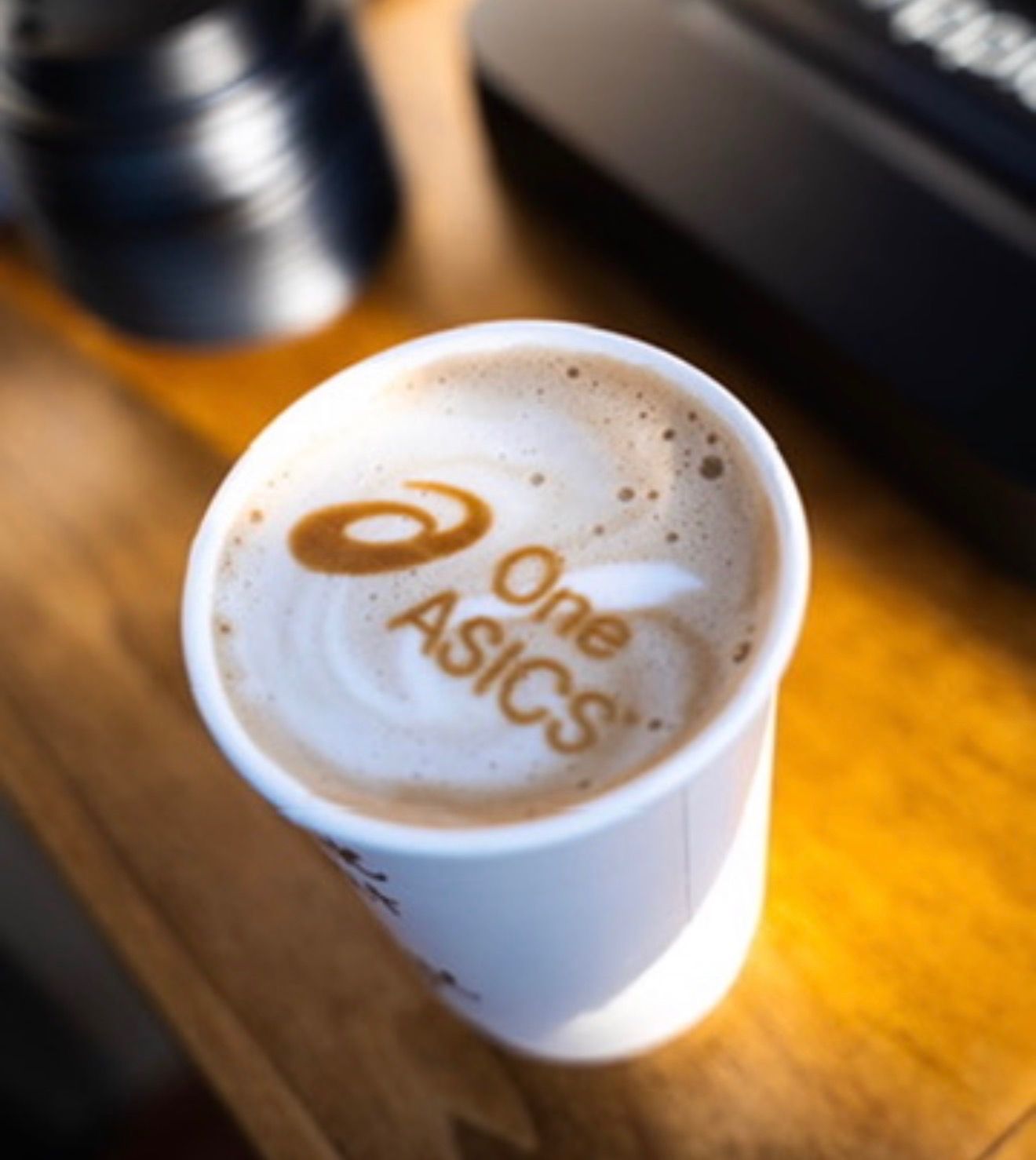 A latte with the One ASICS logo printed in the foam