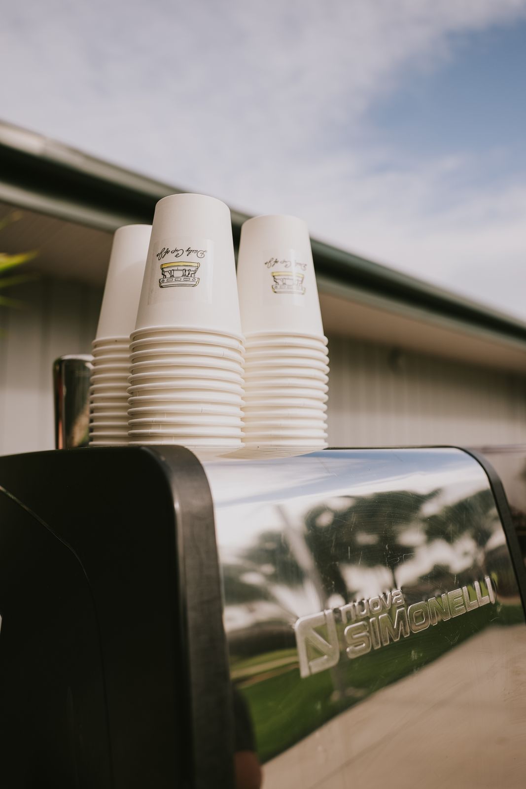 Stacks of Daily Cup of Jo cups on top of the espresso machine