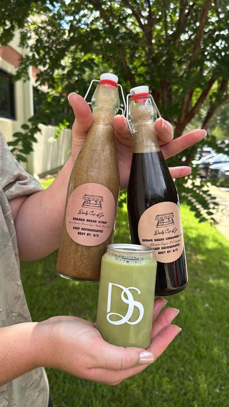 Two swing-top bottles of house-made syrup and a can of matcha